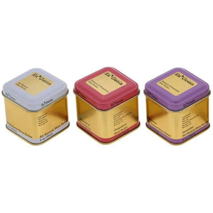 Three tins in white, pink, and purple(from left to right), in a row